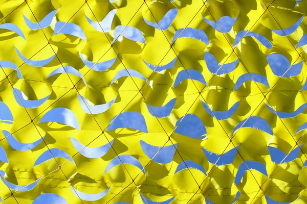 Abstract Blue And Yellow Background, Geometric Shape. Canary Yellow Netting, Cropped Shot. Yellow Netting.Texture Of Yellow Camouflage Nets On Day Time Image.