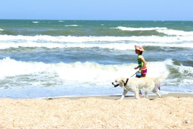 Yaz tatil, seyahat, mutluluk, kavram hayvanlar. Beach.Young üzerinde bir köpekle oynamayı genç kız küçük kız ve Golden Retriever köpek tek başına Köpeğiyle yürüyen Beach.Girl üzerinde çalışan.