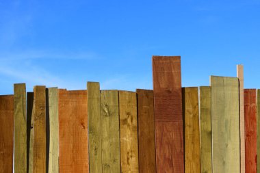 Çok renkli ahşap duvar ve mavi gökyüzü. Renkli duvar ahşap kopya alan bir sürü ile. Ahşap çit ve mavi gökyüzü. Renkli boyalı eski püskü ahşap Resepsiyon arka. Ahşap arka plan.