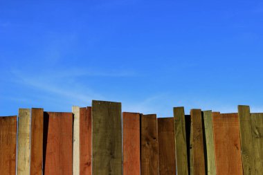 Çok renkli ahşap duvar ve mavi gökyüzü. Renkli duvar ahşap kopya alan bir sürü ile. Ahşap çit ve mavi gökyüzü. Renkli boyalı eski püskü ahşap Resepsiyon arka. Ahşap arka plan.