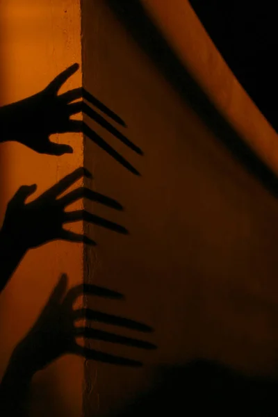 Strange Shadows On The Wall.Terrible Shadows. Abstract Background. Black Shadows Of A Big Hands On The Wall. Silhouette Of A Hands On The Wall. Nightmares. Scary Dreams.