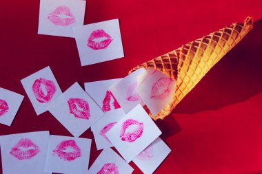 Soyut aşk, Sevgililer Günü kavramı. Waffle konisi ve kırmızı arka planda beyaz bir kağıtta kırmızı ruj izi.. 