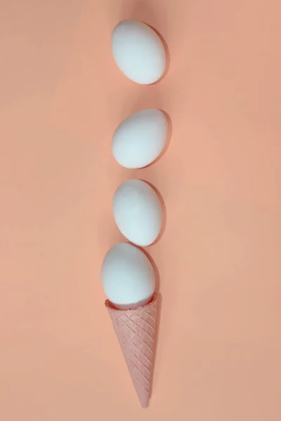ピンクの背景に白い卵とウェーハコーンの水平画像 概要食品の背景 — ストック写真