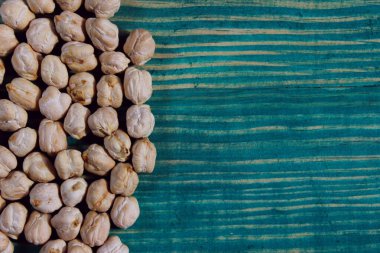 Ahşap masada pişmemiş kuru nohut. Bir yığın baklagil nohut arkaplanı. Sağlıklı gıda geçmişi. 