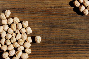 Ahşap masada pişmemiş kuru nohut. Bir yığın baklagil nohut arkaplanı. Sağlıklı gıda geçmişi. 