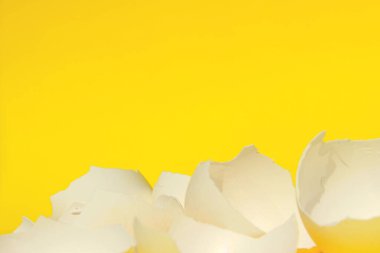 Gıda malzemesinin bulanık görüntüsü. Kırık yumurtalar, yakın plan. Kırık Beyaz Tavuk Yumurta Kabuğu. Sarı Arkaplanda Beyaz Yumurta Kabuğu. Renkli Arkaplan. 