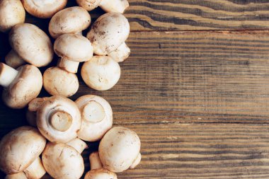 Kahverengi tahta masada beyaz şampiyonlar. Ahşap arka planda mantarlar. Yiyecek konsepti.