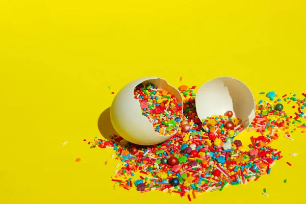 黄色の背景に壊れた白い卵の殻の中の小さな多色のお菓子 イースター 食品の概念 カラフルな食品の背景を抽象化 — ストック写真