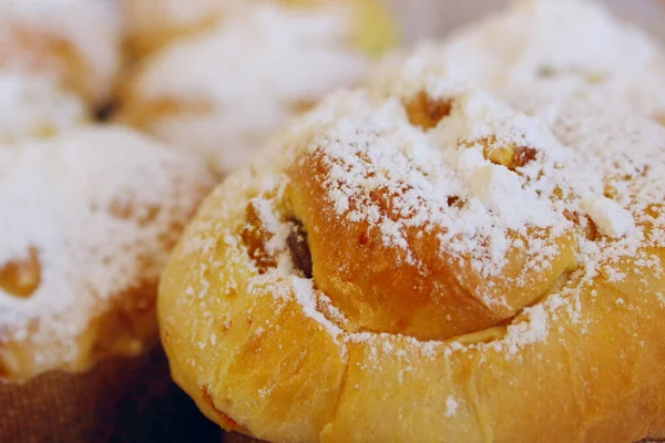 Fresh bakery, cropped shot. Fresh buns with powdered sugar, close up view.