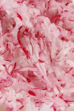 İnce doğranmış turpun bulanık görüntüsü. Soyut gıda arkaplanı, pembe renk, metin için boşluk.