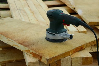 Tahta tahtalarda öğütme makinesi, burç manzarası. Teknoloji, inşaat, onarım konsepti.