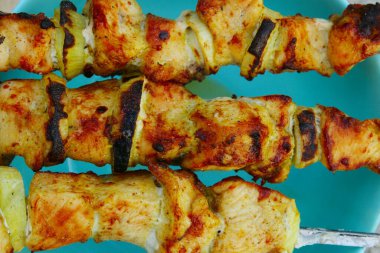 Mavi arka planda sulu ızgara tavuk eti ve soğan. Soyut gıda geçmişi. Kızarmış et..