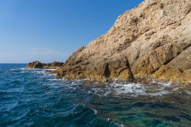 Güneşli bir günde güzel bir kayalık manzara üzerinde denizden görüntülemek