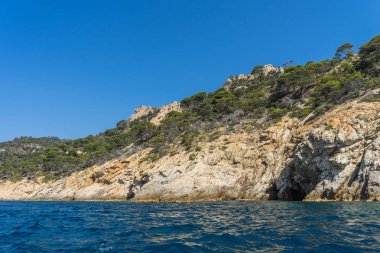 Güneşli bir günde güzel bir kayalık manzara üzerinde denizden görüntülemek