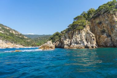 Güneşli bir günde güzel bir kayalık manzara üzerinde denizden görüntülemek
