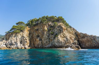 Güneşli bir günde güzel bir kayalık manzara üzerinde denizden görüntülemek