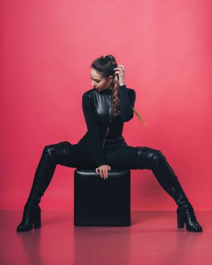 Pembe arka planda poz veren esmer seksi kız.