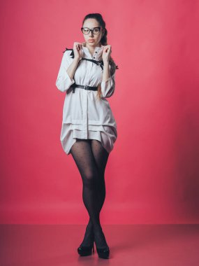 Pembe arka planda poz veren esmer seksi kız.