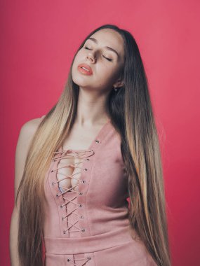 Pembe arka planda poz veren esmer seksi kız.