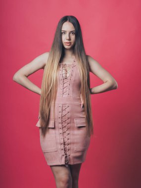 Pembe arka planda poz veren esmer seksi kız.