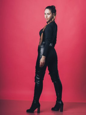 Pembe arka planda poz veren esmer seksi kız.