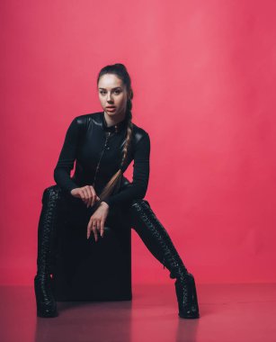 Pembe arka planda poz veren esmer seksi kız.