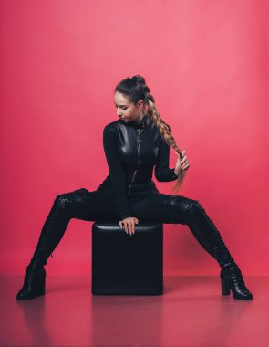 Pembe arka planda poz veren esmer seksi kız.