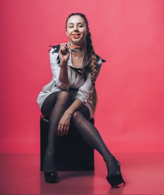 Pembe arka planda poz veren esmer seksi kız.