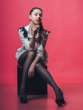 Pembe arka planda poz veren esmer seksi kız.