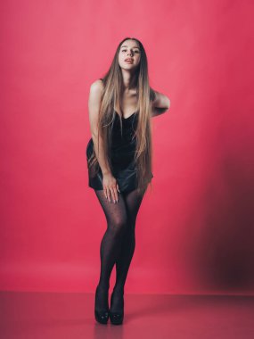 Pembe arka planda poz veren esmer seksi kız.