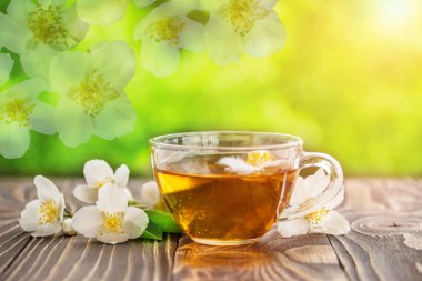 Yasemin çayı ve ahşap arka plan üzerinde Yasemin çiçekleri