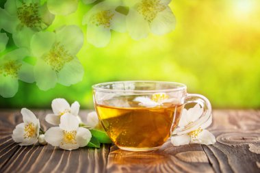 Yasemin çayı ve ahşap arka plan üzerinde Yasemin çiçekleri