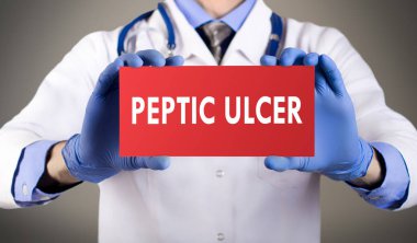 Doctor's hands in blue gloves shows the word peptic ulcer. Medical concept. clipart
