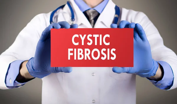 Las manos del doctor en guantes azules muestran la palabra fibrosis quística. Concepto médico . — Foto de Stock