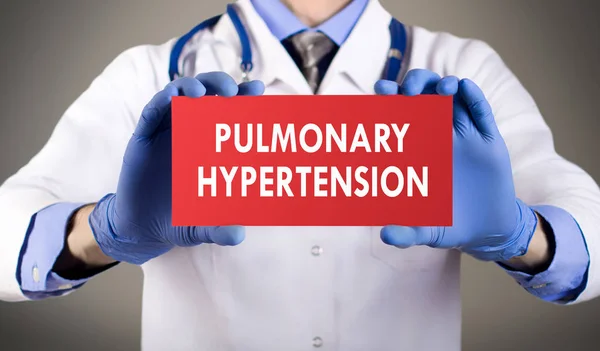 Doktorun mavi eldiven gösterilerinde kelime pulmoner hipertansiyon eller. Tıp kavramı.