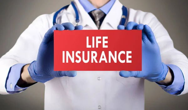 Les mains du docteur en gants bleus montrent le mot assurance-vie. Concept médical . — Photo