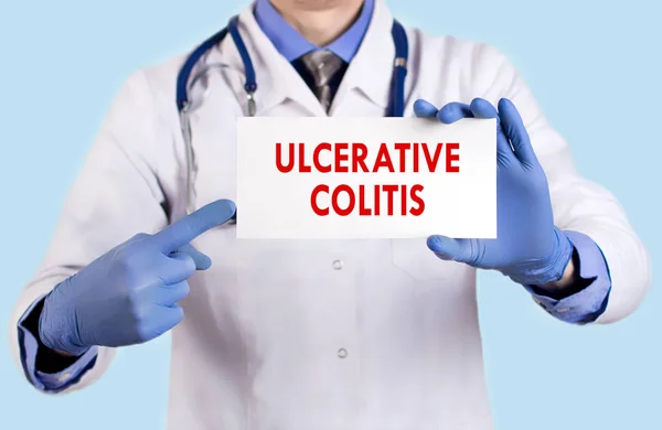 Der Arzt führt eine Karte mit dem Namen der Colitis ulcerosa. Selektiver Fokus. medizinisches Konzept. — Stockfoto
