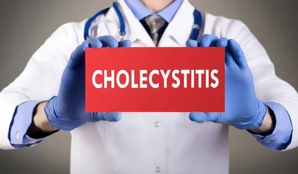 Doctor's hands in blue gloves shows the word cholecystitis. Medical concept. Stock Photo
