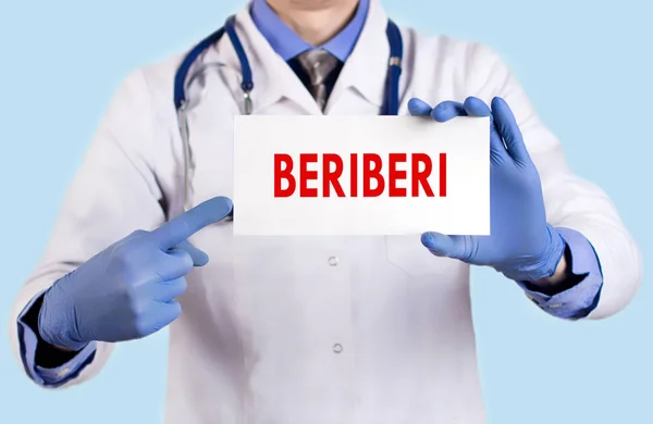 Doctor keeps a card with the name of the beriberi. Selective focus. Medical concept. Royalty Free Stock Photos