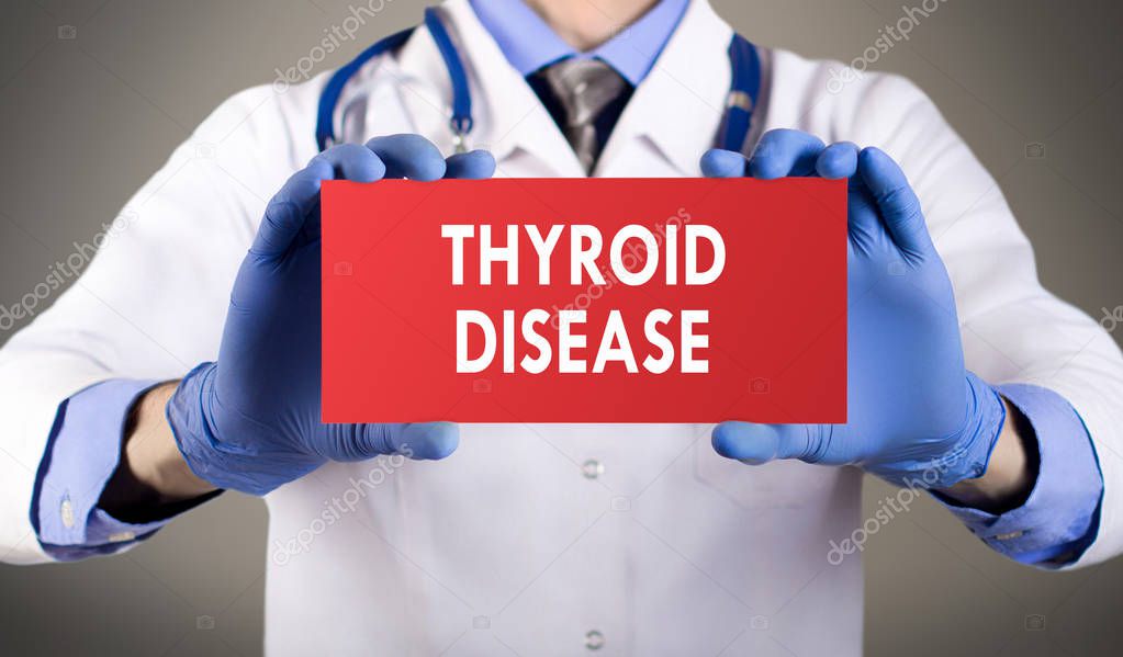 Doctor's hands in blue gloves shows the word thyroid disease. Medical concept.
