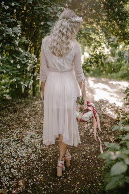 Gelin bir düğün buketi tutuyor.