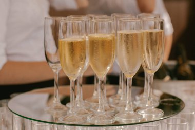 Bir tepsi ile köpüklü şampanya bardağı