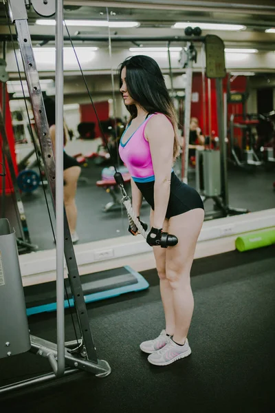 Kız onu triceps makinede sallıyor.