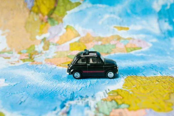 toy car on a background map of the world