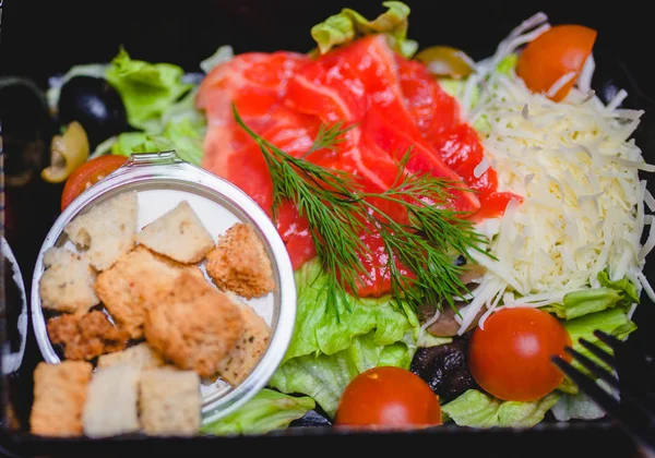 Caesar-Salat mit rotem Fisch, Cracker, Tomaten und Käse — Stockfoto