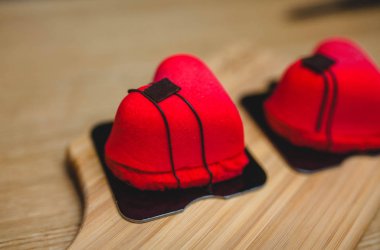 Tahta bir tahtanın üzerinde kırmızı kalp şeklinde tatlı. 14 Şubat