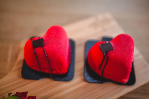 Postre en forma de corazones rojos en una tabla de madera. 14 de febrero — Foto de Stock