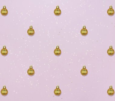 Altın topları ve pembe pastel arka planda yıldız konfetisi olan desen. Noel veya Yeni Yıl kartı.