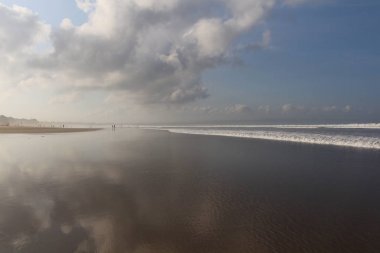 Bulutlar düşük tide, okyanusun kıyısında yansıması