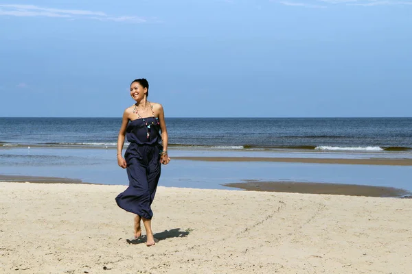 Baltık Denizi, elbiseli sahilde yürüyen kadın